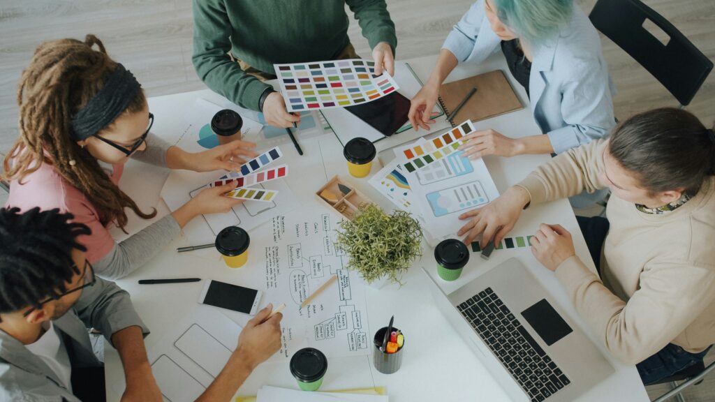 Team einer Landingpage-Agentur entwickelt gemeinsam Designkonzepte und bespricht Farbpaletten, Wireframes und Seitenlayouts.